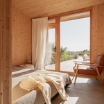 Skrytý dům z dřevěných panelů je jako hobití nora. Využívá svahu, maskuje se terénem. Foto: György Palkó