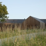 Stěny i střechu domu kryjí dřevěné latě. Maskuje nezvyklou geometrii. Vyniká, přesto nekonkuruje přírodní scenérii. Foto: Christian Brandstätter