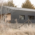 Černý plášť chrání dům mezi ořešáky. Vlnitou mají fasádu i střechu Foto: Sirokai Levente