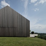 Stěny i střechu domu kryjí dřevěné latě. Maskuje nezvyklou geometrii. Vyniká, přesto nekonkuruje přírodní scenérii. Foto: Christian Brandstätter