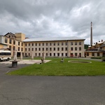 Uprostřed, na místě bývalé malé hasičské zbrojnice, kterou nechali jako jednu z mála budov odstranit stojí dnes Foodtruck Fabrika a pořádají se zde kulturní akce. Původní vodní prvek a kousek zeleně zlidšťuje průmyslový areál. Zaměstnanci se zde měli i díky takovým detailům cítit příjemněji. Dnes trávník slouží k posezení a relaxaci na kulturních akcích. Foto: Oldřich Rejl