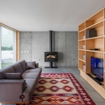 Půdorys je jednoduchý a funkční, s jasným oddělením denních a nočních zón. Dole, kde to žije přes den – obývací pokoj, kuchyň a jídelna – místnosti tvoří propojený prostor. Foto: Joao Morgado