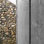 Vstupní prostor lemují stříbrně prošedlé dřevěné desky a obě křídla propojuje prosklený spojovací trakt, který poskytuje výhledy do okolí během přechodu mezi jednotlivými částmi domu. Foto: Gilbert McCarragher Vstupní prostor lemují stříbrně prošedlé dřevěné desky a obě křídla propojuje prosklený spojovací trakt, který poskytuje výhledy do okolí během přechodu mezi jednotlivými částmi domu. Foto: Gilbert McCarragher