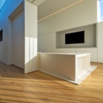 Vestavěný nábytek se tu nedotýká stropu. Je vsazen do stěn a koresponduje s prosvětlujícími střešními okny. Foto: Shane Lynham