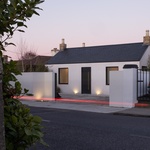 Zvenčí je Beaumont Lodge natřena bílou barvou a okenní otvory rámují ocelové ostění. Zapuštěné okapy zajišťují, že nejsou viditelné žádné svody ani okapy. Foto: Shane Lynham