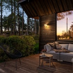 Prodloužené okapy střechy se mění a nabízejí částečně kryté venkovní prostory. Stejně jako okolní kmeny stromů má dům tmavý dřevěný obklad a světlé vnitřní jádro. Foto: Finn Ståle Felberg Prodloužené okapy střechy se mění a nabízejí částečně kryté venkovní prostory. Stejně jako okolní kmeny stromů má dům tmavý dřevěný obklad a světlé vnitřní jádro. Foto: Finn Ståle Felberg