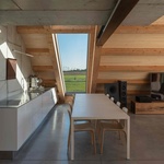 Zvenčí zůstává budova tajemná a uzavřená. Jednopodlažní, klínovitý objem je obložen jednotnou „kůží“ – sendvičovými panely v barvě nerezové oceli. Foto: Lukas Mykolaitis Zvenčí zůstává budova tajemná a uzavřená. Jednopodlažní, klínovitý objem je obložen jednotnou „kůží“ – sendvičovými panely v barvě nerezové oceli. Foto: Lukas Mykolaitis