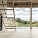 Nová přístavba také skrývá dramatický zapuštěný vstup vytesaný do svahu, vedoucí pod nízkou doškovou střechu a krytou chodbou uprostřed nové přístavby. Foto: Andrea Agatzke