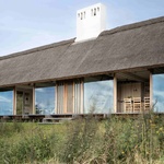 S nízkou doškovou střechou a odhalenou dřevěnou konstrukcí vzdával dům hold tradičním zemědělským usedlostem v oblasti a zároveň zaujal neotřelý, funkcionalistický přístup. Foto: Andrea Agatzke