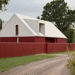 Červeně natřené dřevěné stěny a bílá střecha z vlnitého plechu tvoří základ pro &bdquo;odvážný a osobitý&ldquo; exteriér House Comet. Rodinného domu v lotyšské Rize, který navrhlo místní architektonické studio Gaiss. Foto: Madara Kuplā