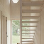 Vstupní hala slouží jako centrální komunikační uzel, který propojuje všechny zóny domu – obě patra, přední nádvoří a zahradu. Tento prostor otevírá celý průřez budovy a vizuálně i fyzicky propojuje interiér se zahradou. Foto: Madara Kuplā