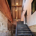 Historické trámy, sloupy a části původního pláště nejsou v projektu pouhou dekorací. Zůstávají plnohodnotnou součástí architektonického výrazu a připomínají původní funkci budovy. Foto: David Aebi Historické trámy, sloupy a části původního pláště nejsou v projektu pouhou dekorací. Zůstávají plnohodnotnou součástí architektonického výrazu a připomínají původní funkci budovy. Foto: David Aebi