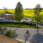 Vstupní předprostor areálu byl doplněn o kolárnu s možností občerstvení cyklistů. Vlastní areál začíná až za novým mostkem. © Andrea Thiel Lhotáková