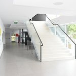 Foyer ZUŠ s grafikami Karla Malicha. Prostoru vévodí výrazné schodiště u prosklené stěny