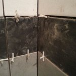Děsivý kout s extrémně zašpiněným materiálem, neprůběžnými spárami rozličných šířek a s improvizací distančními křížky