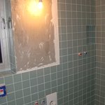 Průběh obkládání koupelny v přízemí - V přízemí jsme zvolili světle zelený skleněný obklad a jako dlažbu bílou skleněnou mozaiku