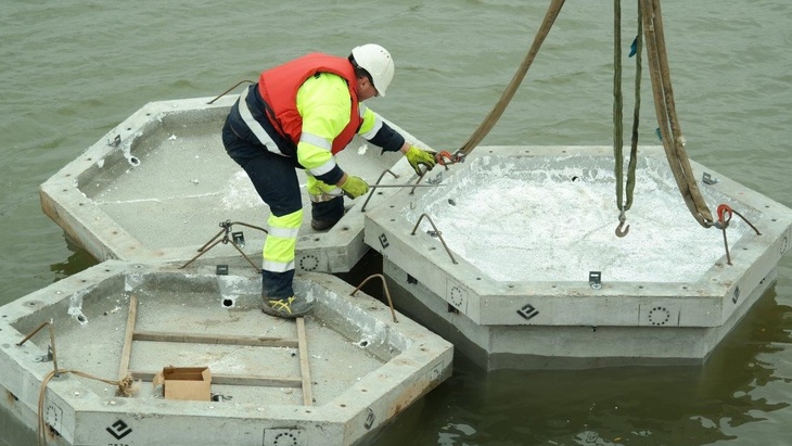 Betonové rybáčí ostrůvky. Autojeřáb zvedal a pokládal šestiboké hranoly z vláknobetonu na hladinu těžebního jezera. Betonové hranoly byly opatřeny ohrádkou a vysypány štěrkem. Foto CEMEX