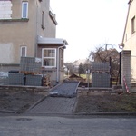 Plocha od brány ke garáži, kde byly původně položeny jen dva pásy betonových dlaždic, bude plně vydlážděná pojezdovými betonovými tvarovkami od firmy Best; stejnými tvarovkami, avšak pouze s pochozí nosností budou vydlážděny i ostatní plochy kolem domu, včetně chodníku od branky směrem k verandě.