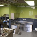 Tato kuchyně v restauraci je obložena stěnovými dílci v šedé a zelené v lesklé variantě. © Zdroj: ANVI Trade s. r. o.
