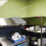 Tato kuchyně v restauraci je obložena stěnovými dílci v šedé a zelené v lesklé variantě. © Zdroj: ANVI Trade s. r. o.