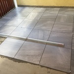 nvestor vybral velký formát dlažby 60 x 60 se vzhledem imitace přírodního kamene, značka Rako, vzor Random tmavě šedá, spáry mají tloušťku 5 mm, menší spáry nejsou z důvodu velikosti dlaždic možné