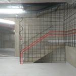 Příklad kombinace materiálů použitých v prostoru garáží (beton, betonářská výztuž v kombinaci s výraznou barvou madla zábradlí. Autor: Ing. arch. Jakub Kopecký 