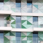 Bytový dům ve Francii s fasádou, kombinující kontaktní zateplovací systém StoTherm Classic, předsazený provětrávaný zateplovací systém StoVentec Glass, složený ze skleněných panelů různých tvarů a bílý fasádní povrch  StoSignature. 
