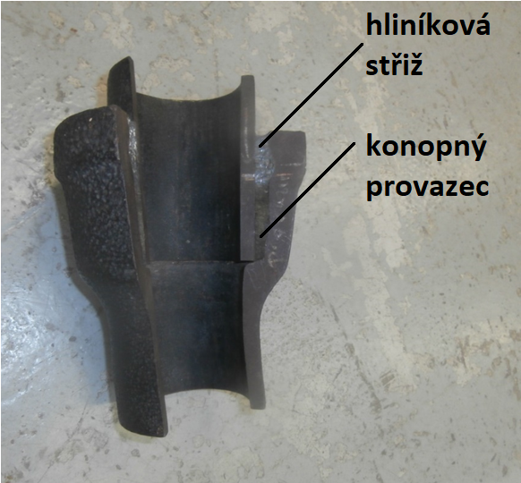 Detail spoje litinové trubky v řezu – ve spodní části je těsnění z konopného provazu, v horní těsnění z hliníkové vaty (vlny, střiže) Detail spoje litinové trubky v řezu – ve spodní části je těsnění z konopného provazu, v horní těsnění z hliníkové vaty (vlny, střiže)