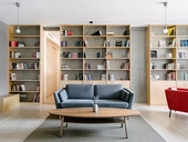 Světlý, klidný byt s velkou knihovnou, která tvoří prostor
