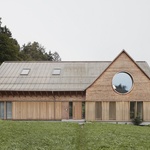 Dům kombinuje dřevo a beton. Do kraje se rozhlíží kulatými okny Foto: Adolf Bereuter