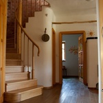 Schodiště na severu domu s úložným prostorem pod schodištěm. Schodnice, madlo i vnitřní dveře jsou natřené přírodním olejem