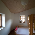 Místnosti jsou volnější bez viditelných vestavěných skříní. Na podlaze jsou dubová prkna natřená dřevním olejem, hliněné omítky mají zaoblené rohy