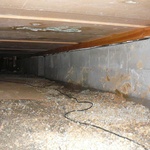 Obr. 4. V montážním stádiu zaplavení crawl space přívalovým deštěm. Na zemině netex a zához štěrkem. Poddimenzovaní větracích otvorů vedlo k zplesnivění podhledu. (Foto: J. Smola).